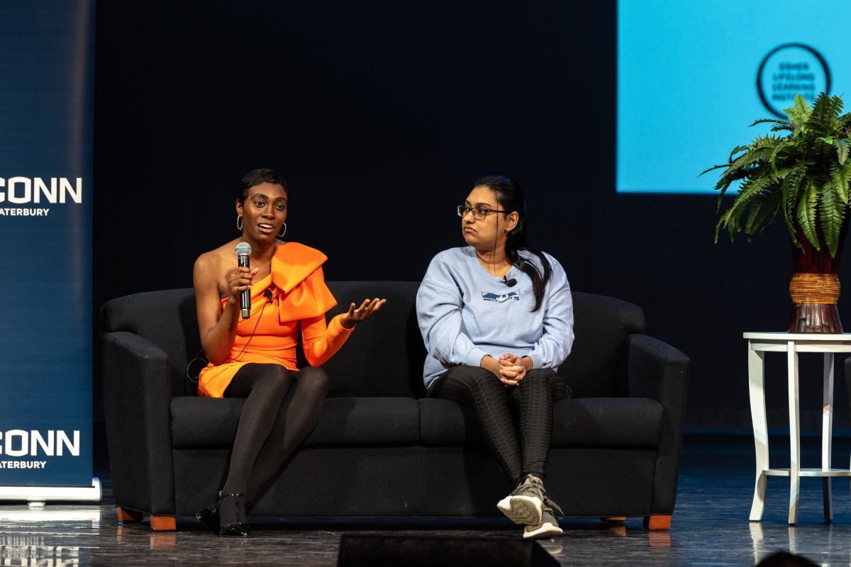 Shavana Clarke, Miss Connecticut USA 2024 and a UConn alum, speaks to the WISHfest audience from a couch on the stage.