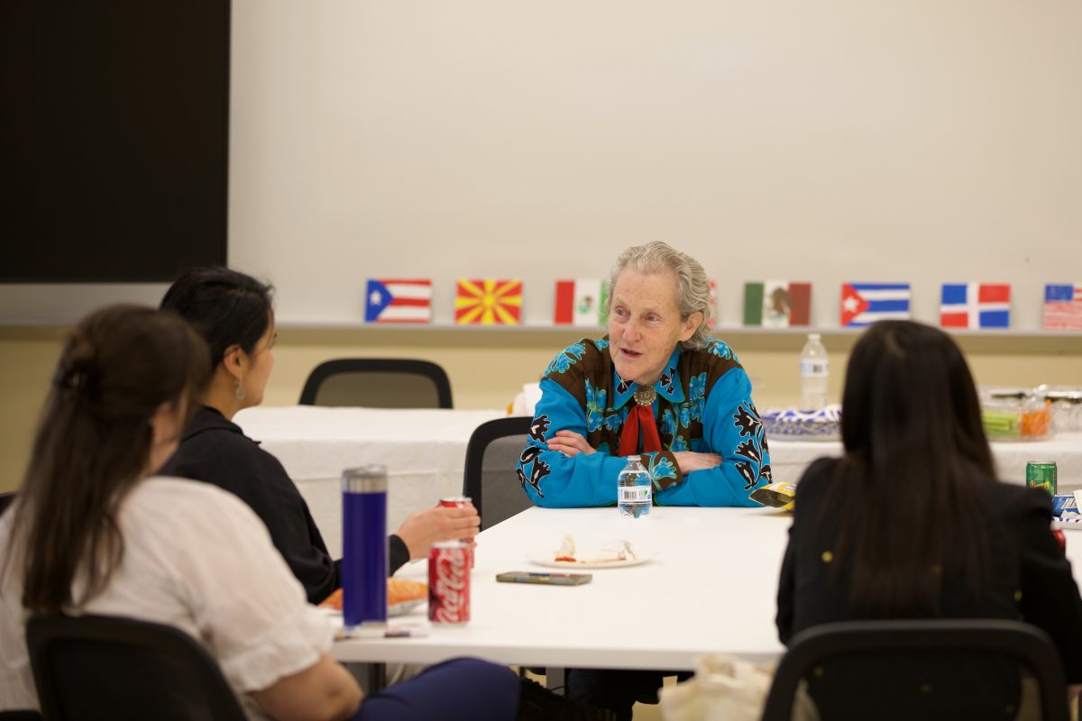 Dr. Temple Grandin sitting listening to students